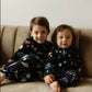 toddler boy and baby boy wearing matching bamboo baby and toddler pajamas with outer space print